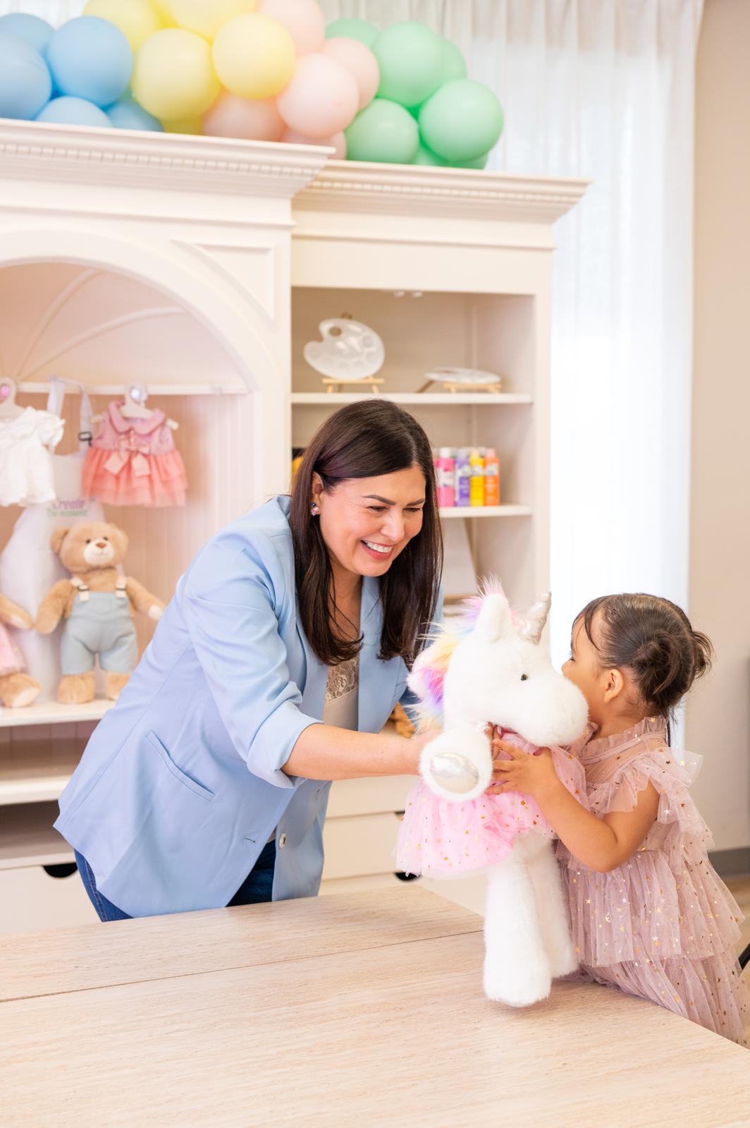 Little guest giving her new unicorn plush friend a kiss