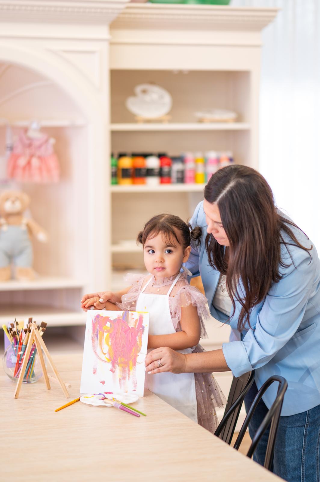Mother and daughter painting a canvas together