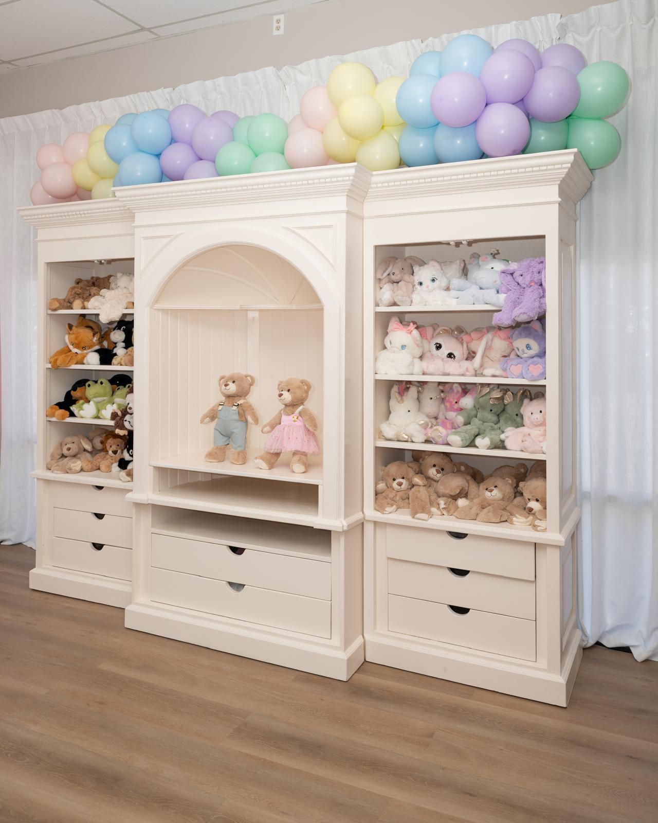 Plush friends and outfits displayed on the studio shelves