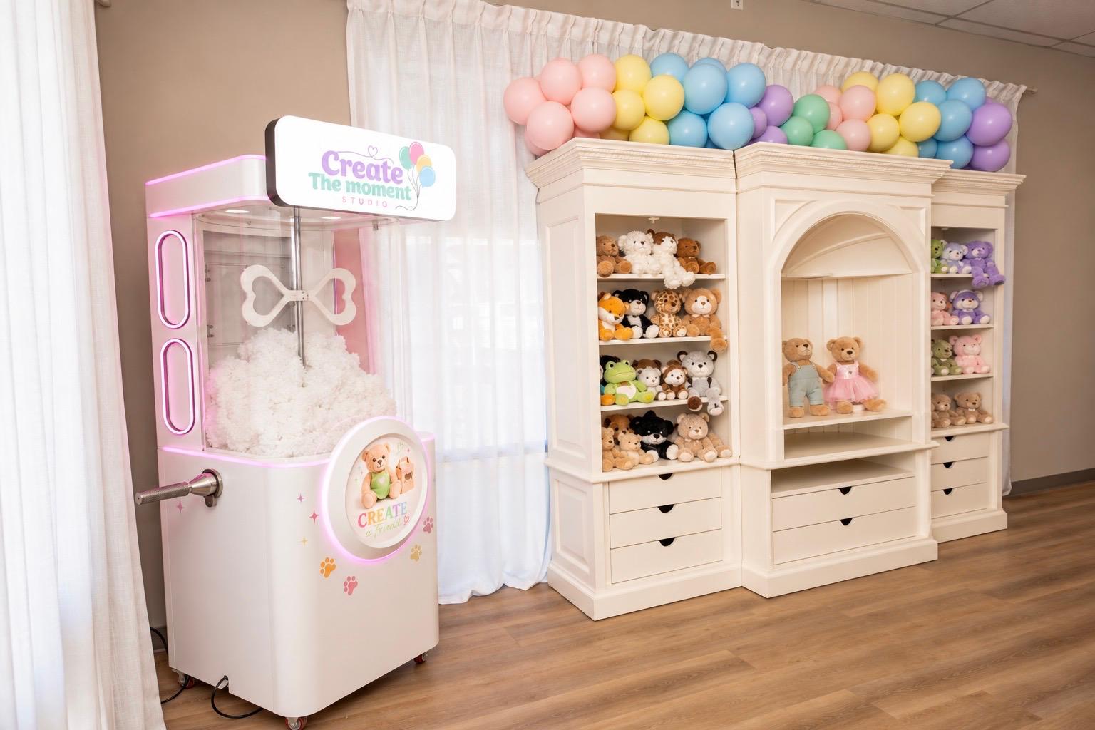 Studio shelves filled with plush friends under a pastel balloon arch
